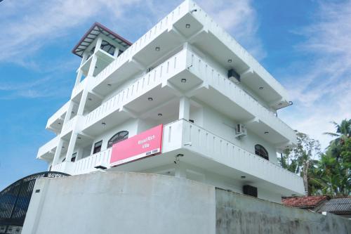 a white building with a sign on it at Royal Rich Villa in Ambalangoda