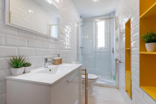 a white bathroom with a sink and a toilet at Apartamento KUIA en el centro de Barakaldo al lado del metro in Barakaldo