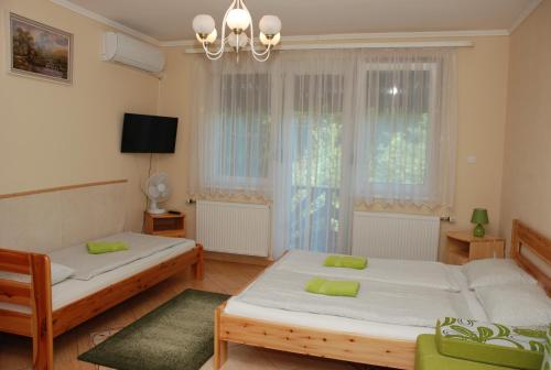 um quarto com 2 camas e uma janela em Zöldike Vendégház em Kaposvár