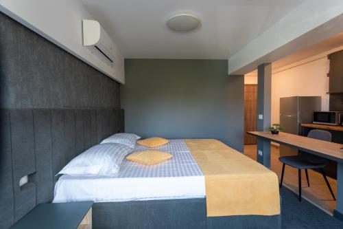 een slaapkamer met een bed, een bureau en een keuken bij Corso Apartments B&B in Focşani