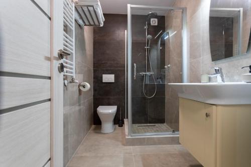 Un baño con ducha, inodoro y lavabo. en Corso Apartments B&B, en Focşani
