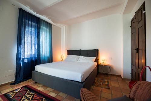 a bedroom with a bed and two chairs and a window at Casa Silvana in Alba