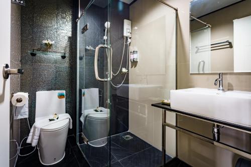 a bathroom with a shower and a toilet and a sink at Lux Boutique Hotel in Nonthaburi