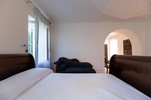 a bedroom with a bed and a blue chair at Casa Silvana in Alba