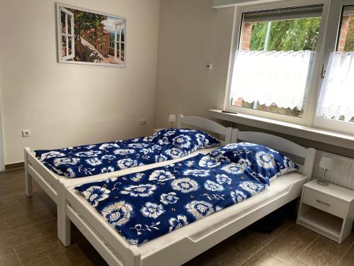 1 dormitorio con 2 camas y almohadas azules y blancas en Domi's Gästehaus, en Bergheim