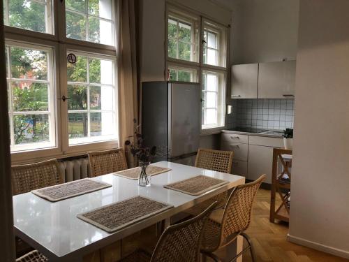 una cucina con tavolo bianco e alcune finestre di Ela Apartments Berlin a Berlino