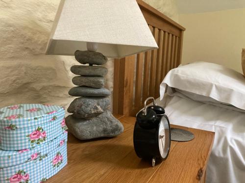 a lamp on a table next to a bed at Courtyard Apartment in Shepton Mallet