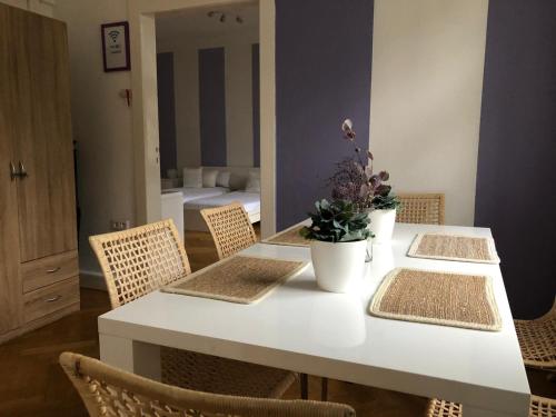 a table with chairs and a white table with flowers on it at Ela Apartments Berlin in Berlin