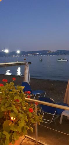 a couple of chairs and an umbrella on a beach at Artemis Hotel in Amarinthos