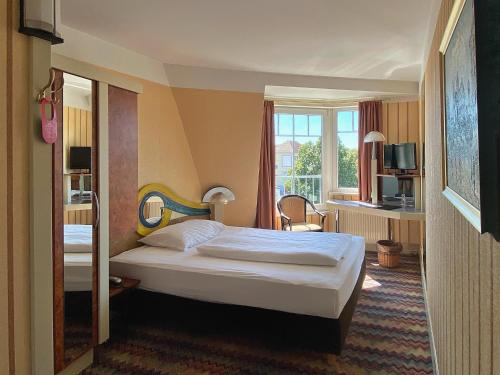 ein Hotelzimmer mit einem Bett und einem Fenster in der Unterkunft Zum Grünen Turm in Hohen Neuendorf