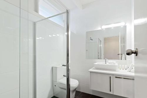 a white bathroom with a toilet and a sink at Comfort Inn Flinders on Main in Port Pirie