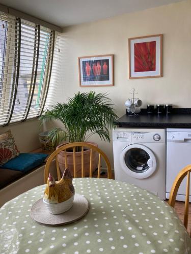 a kitchen with a table with a chicken sitting on it at Courtyard Apartment in Shepton Mallet