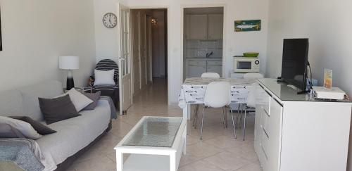 Il comprend un salon doté d'un canapé et d'une table avec une télévision. dans l'établissement Cassiopee II, à Les Sables-dʼOlonne