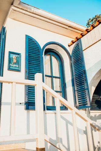 a house with blue shutters and a white fence at Büyükada Loc'ada in Adalar