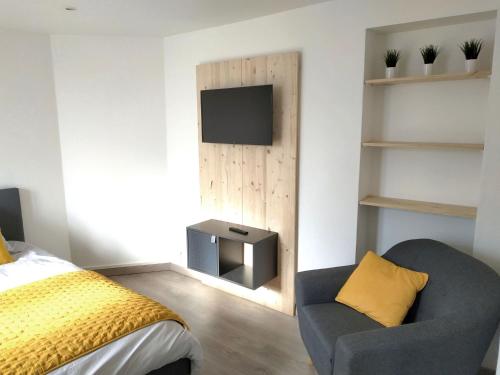 a bedroom with a bed and a tv and a chair at Sea view & Beach Studio Apartment - Blue Horizon in Dunkerque