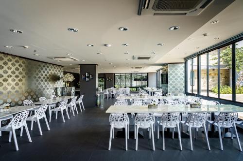 a dining room with tables and white chairs at Lux Boutique Hotel in Nonthaburi