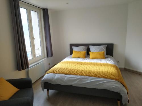 a bedroom with a bed with yellow pillows and a window at Sea view & Beach Studio Apartment - Blue Horizon in Dunkerque