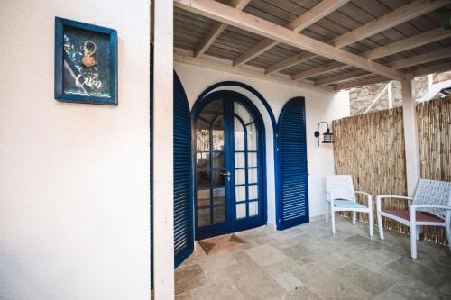 a porch with a blue door and two chairs at Büyükada Loc'ada in Adalar