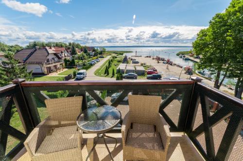 a balcony with two chairs and a table and a street at Hotel Kahlberg in Krynica Morska