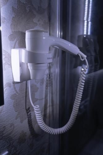 a white phone is hanging on a wall at ROYAL GARDENS in Caserta