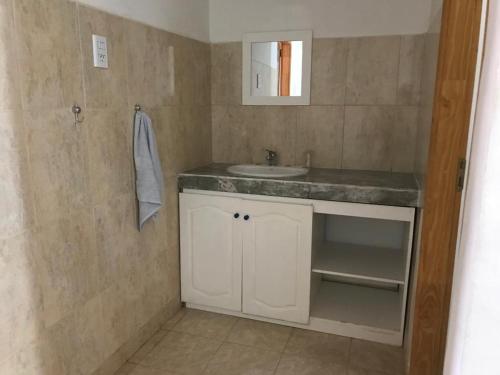 a bathroom with a sink and a mirror at Casa tipo duplex con patio y parrilla. Muy cómoda in Neuquén