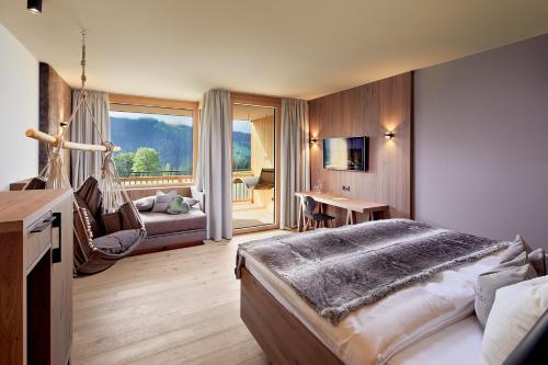 a bedroom with a bed and a living room at Gut Sonnberghof in Mittersill
