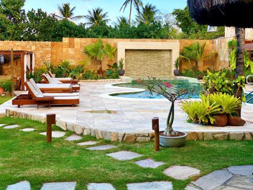 a patio with chairs and a pool in a yard at Natal Dunnas Hotel in Natal