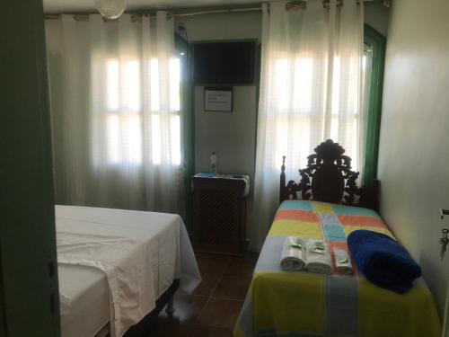 1 dormitorio con 2 camas y ventana en hospedagem quarto casa da wal en Goiás
