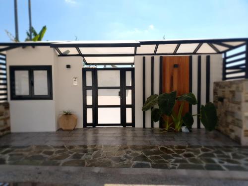 - une vue sur une maison avec une porte et une plante dans l'établissement Olivujoj Villajoj - Deluxe Villa with Detached Pool House, à Anavyssos