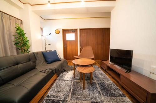 a living room with a black couch and a table at HOTEL Fujimi Tokyo in Tokyo