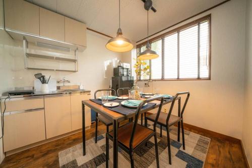 a kitchen with a table and chairs in a room at HOTEL Fujimi Tokyo in Tokyo