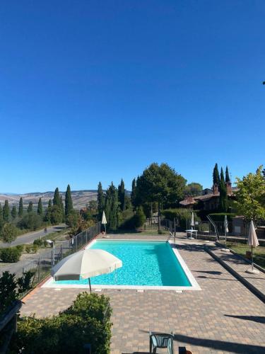 una piscina con ombrellone e cielo azzurro di Regina home a Contignano