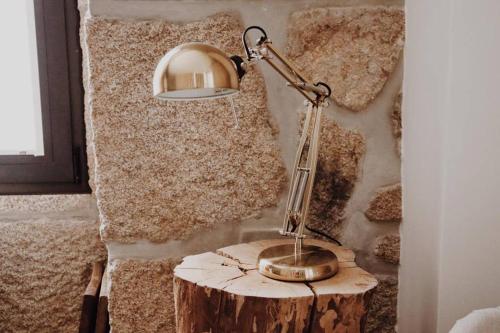a lamp sitting on top of a tree stump at Madrinha Country House in Antas