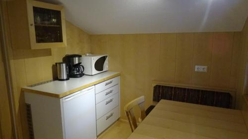 a kitchen with a table and a microwave on a counter at Pension Edelweiss in Damuls