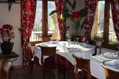 a dining room with a table and chairs and windows at Finca Rincón de la Vega in Los Cortos
