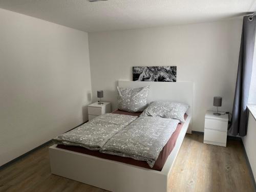 1 dormitorio blanco con 1 cama y 2 mesitas de noche en Großer Vampir, en Thale
