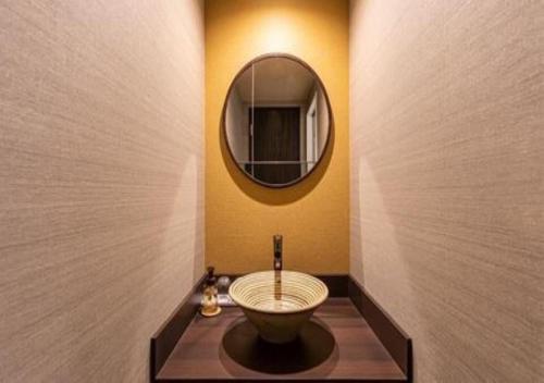 La salle de bains est pourvue d'un lavabo et d'un miroir. dans l'établissement Galois Hotel Shinokubo, à Tokyo