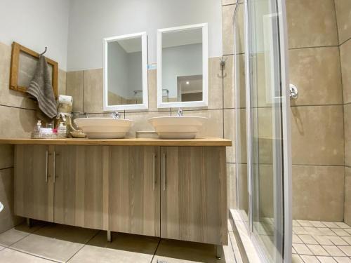 a bathroom with two sinks and a shower at De Akker Guest House Oudtshoorn in Oudtshoorn