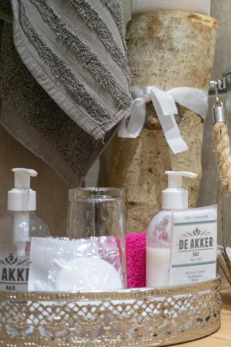 a metal basket with soap and other bathroom items on a table at De Akker Guest House Oudtshoorn in Oudtshoorn