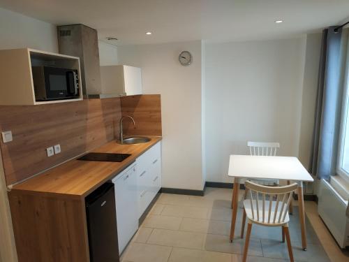 a small kitchen with a table and a counter top at Sea view & Beach Studio Apartment - Blue Horizon in Dunkerque