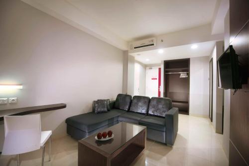 a living room with a couch and a table at favehotel Padjajaran Bogor in Bogor