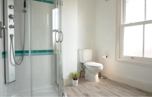 a bathroom with a toilet and a glass shower at Eastside View Apartment in Whitby