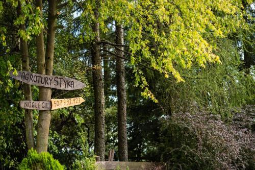 two street signs on a pole in a park at Agroturystyka u Julii in Helusz