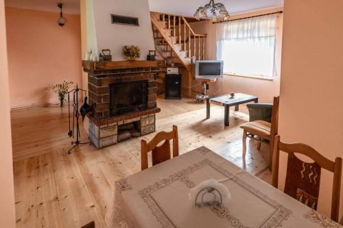 a living room with a fireplace and a dining table at Agroturystyka u Julii in Helusz