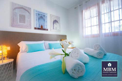 een slaapkamer met een bed met handdoeken en een bloem erop bij Bungalow Marta Agaete in Agaete