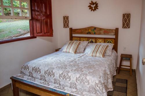 a bedroom with a bed and a window at Pouso dos Querubins in Tiradentes