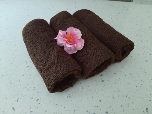 two towels with a flower on top of a counter at Вила МАЯ in Krayni Dol