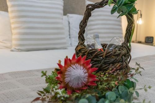 a basket with a flower on a table at De Akker Guest House Oudtshoorn in Oudtshoorn