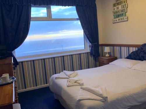 a bedroom with a bed and a large window at Canasta Hotel in Blackpool