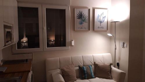 a living room with a white couch and some windows at Apartamentos Marques De La Merced in Málaga